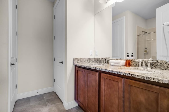 bathroom featuring a tile shower, vanity, and tile patterned flooring