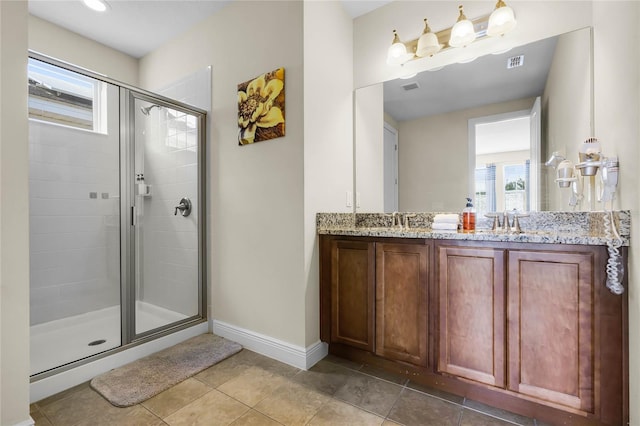 bathroom with tile patterned flooring, vanity, and walk in shower