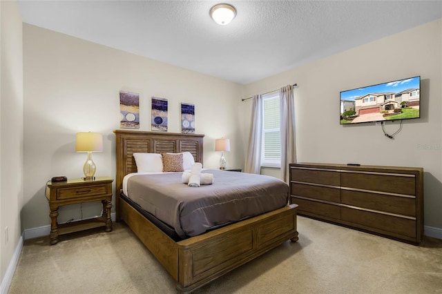 bedroom with light carpet and a textured ceiling