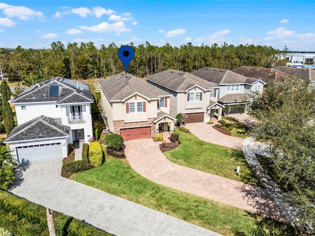 view of front of property with a garage, a balcony, and a front yard