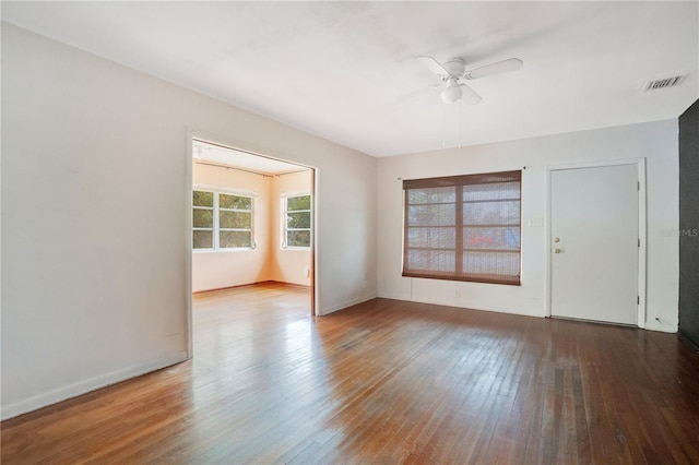 empty room featuring baseboards, hardwood / wood-style floors, visible vents, and a ceiling fan