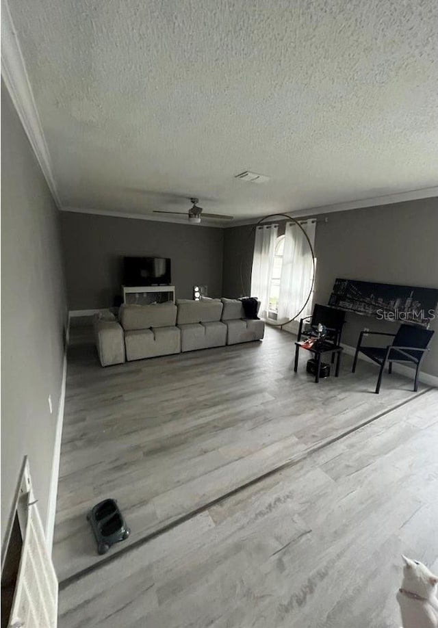 living room with crown molding, hardwood / wood-style flooring, a textured ceiling, and ceiling fan