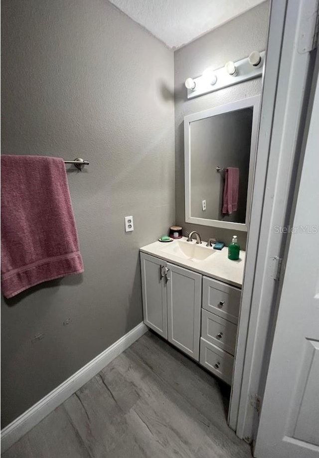 bathroom featuring vanity, wood-type flooring, and a textured ceiling
