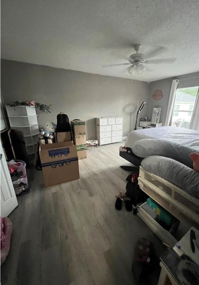 bedroom featuring hardwood / wood-style flooring, ceiling fan, and a textured ceiling