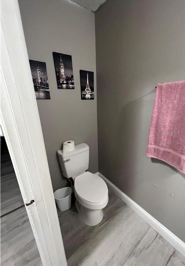 bathroom with wood-type flooring and toilet