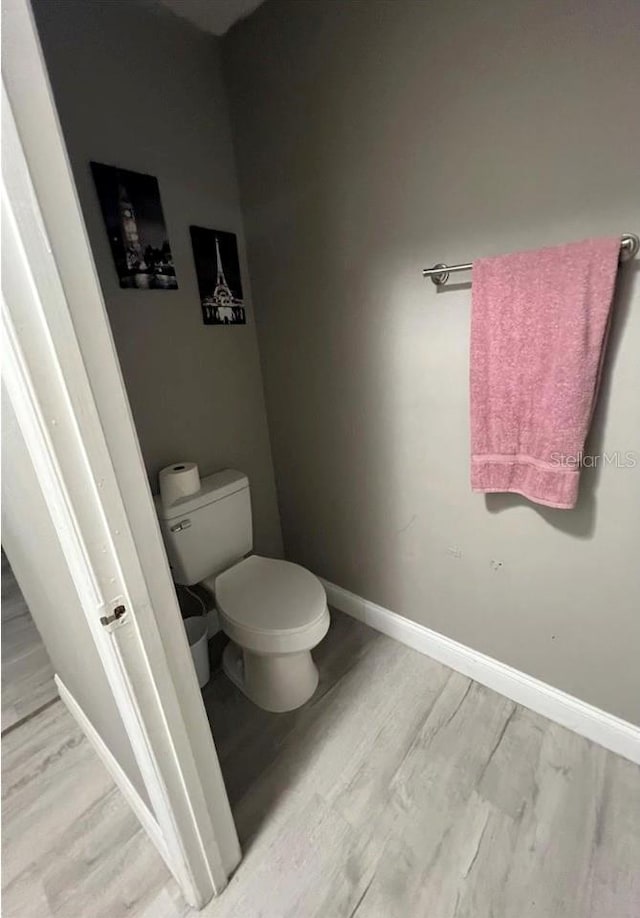 bathroom with hardwood / wood-style flooring and toilet