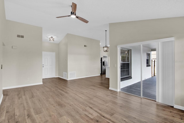 unfurnished living room with baseboards, ceiling fan, visible vents, and wood finished floors