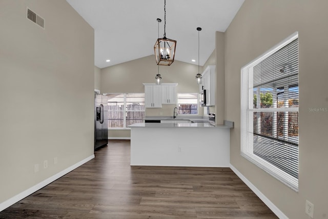 kitchen with a peninsula, dark wood-style flooring, a sink, white cabinets, and appliances with stainless steel finishes