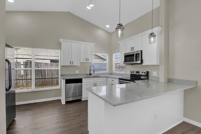 kitchen with stainless steel appliances, dark wood-type flooring, white cabinetry, a sink, and a peninsula