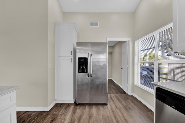 kitchen with wood finished floors, visible vents, white cabinetry, light countertops, and appliances with stainless steel finishes