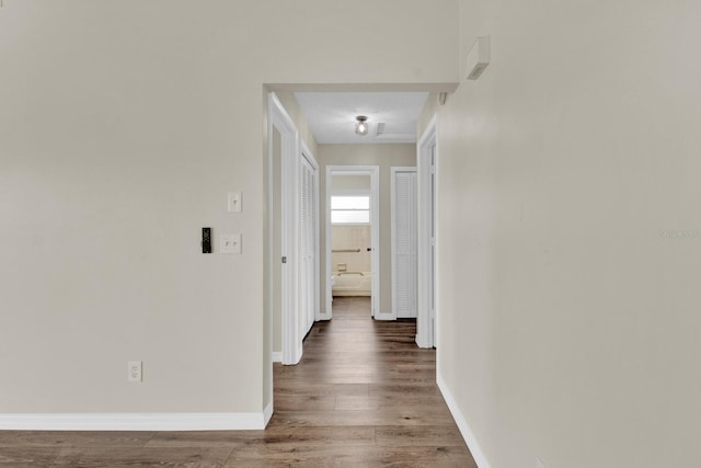 hallway with wood finished floors and baseboards