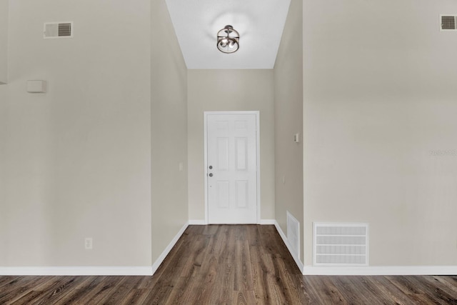 entryway with baseboards, visible vents, and dark wood-type flooring