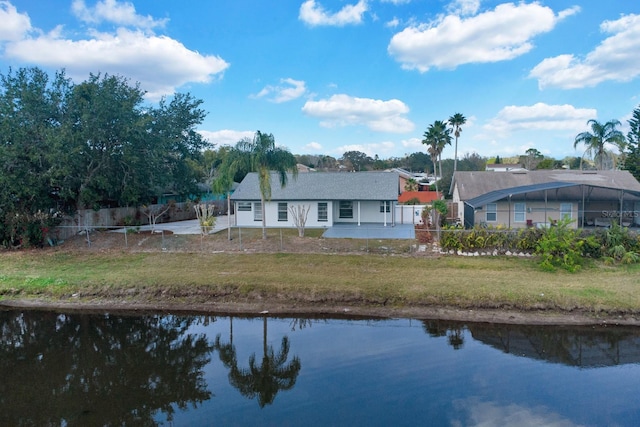 back of house featuring a water view, fence, and a yard