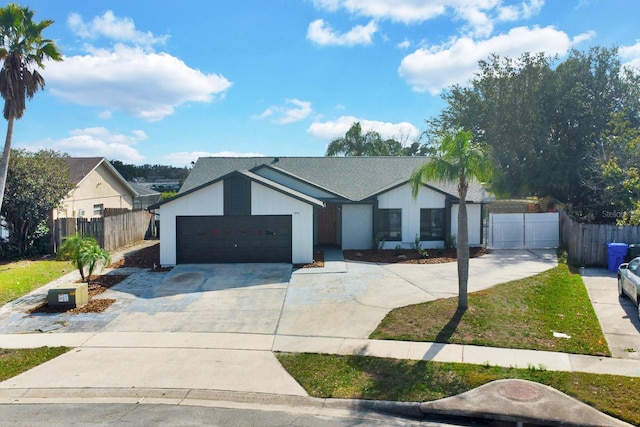 view of front of house featuring a garage, driveway, and fence