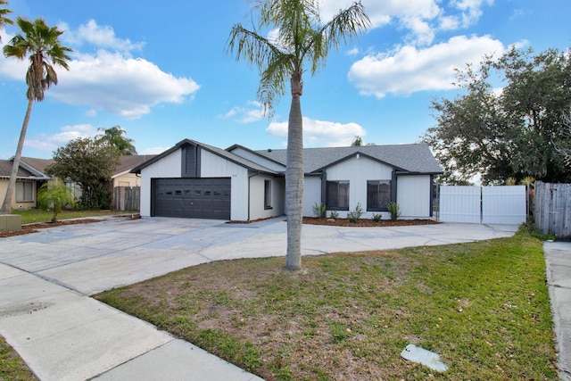 view of front of property with a gate, driveway, an attached garage, and fence