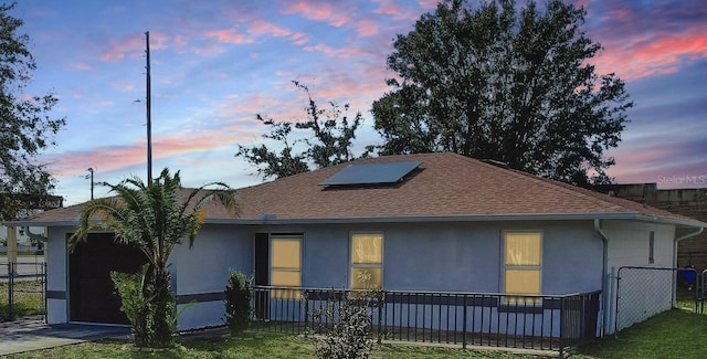 property exterior at dusk featuring a lawn