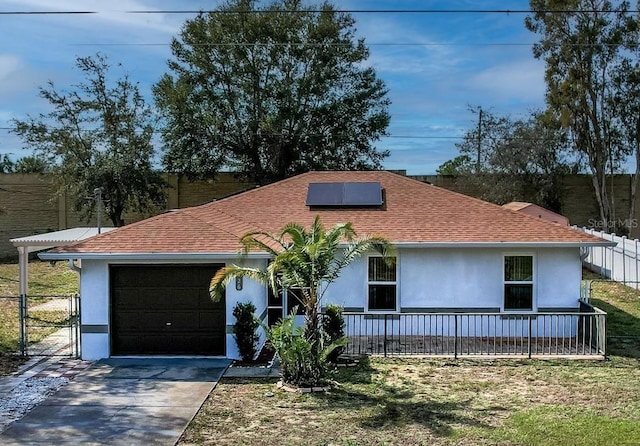 ranch-style house with a garage, a front lawn, and solar panels