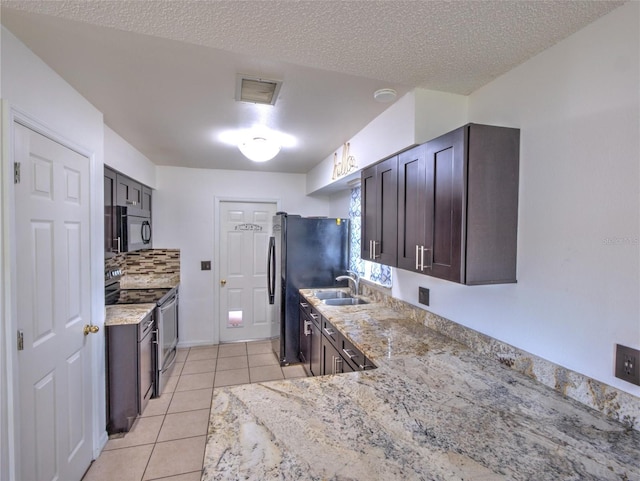 kitchen featuring light stone counters, light tile patterned flooring, sink, and black appliances