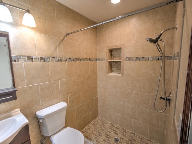 bathroom featuring vanity, toilet, and a tile shower