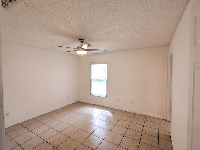 empty room with light tile patterned floors, a textured ceiling, and ceiling fan