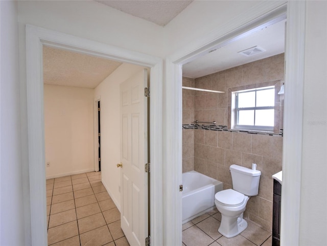 full bathroom featuring tiled shower / bath combo, vanity, a textured ceiling, tile patterned floors, and toilet