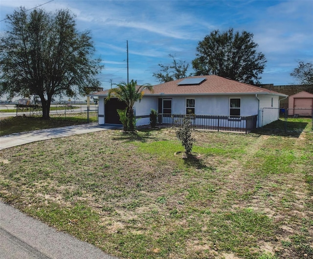 ranch-style house with a garage, a front yard, and solar panels