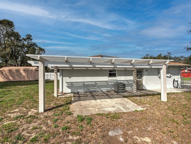 back of property with a pergola, a yard, and a patio area