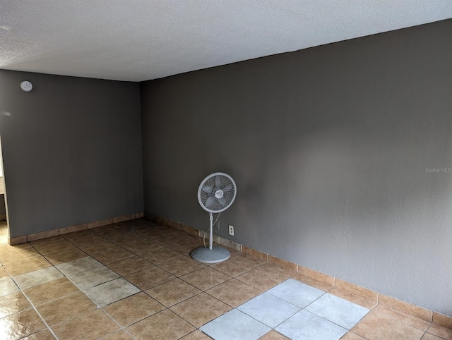 tiled empty room with a textured ceiling