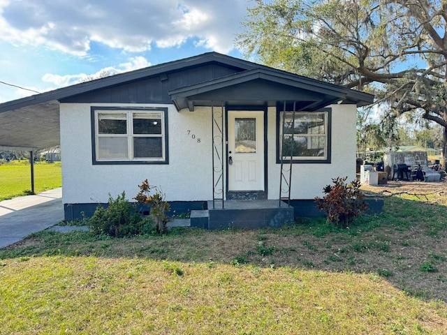 bungalow-style home featuring a carport and a front lawn