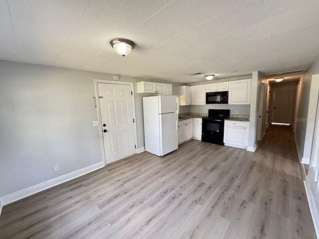 kitchen featuring white cabinetry, black appliances, a textured ceiling, and light wood-type flooring