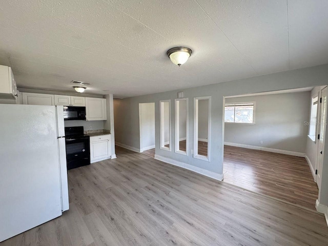 kitchen with white cabinetry, light wood-type flooring, a textured ceiling, and black appliances