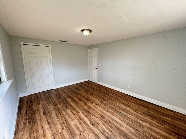 unfurnished bedroom featuring wood-type flooring and a closet