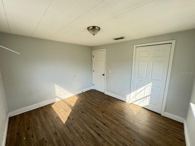 unfurnished bedroom with dark wood-type flooring