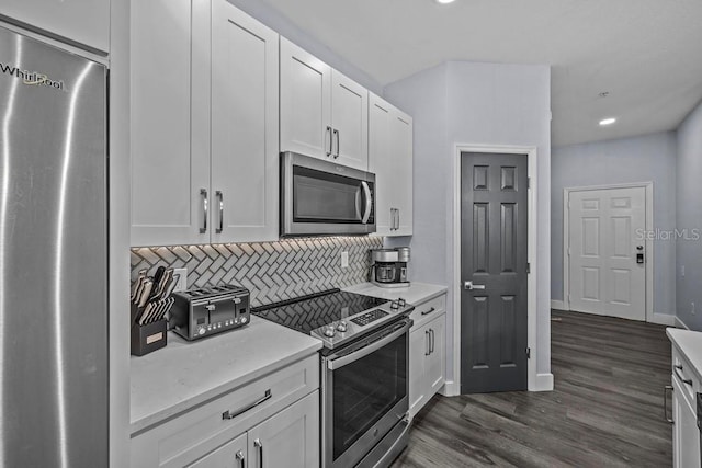 kitchen with backsplash, stainless steel appliances, dark hardwood / wood-style flooring, and white cabinets