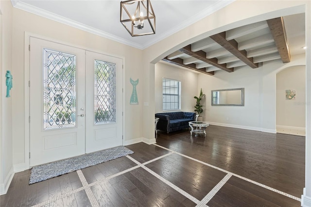 entryway with a healthy amount of sunlight, wood-type flooring, arched walkways, and baseboards