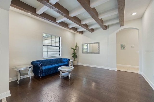 living area featuring baseboards, arched walkways, coffered ceiling, and hardwood / wood-style floors