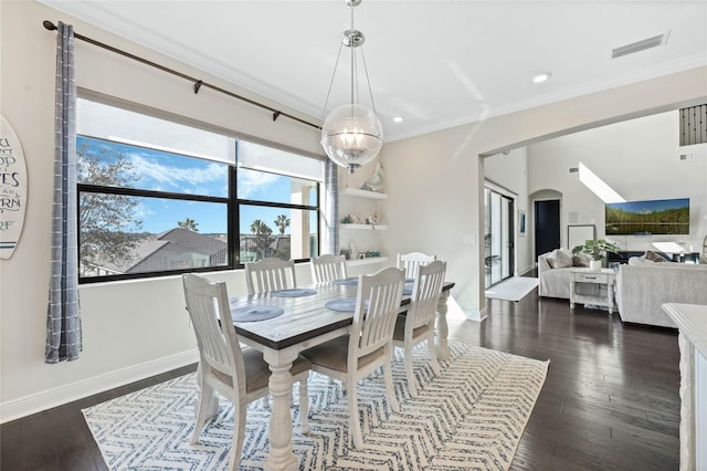 dining room featuring visible vents, arched walkways, dark wood-type flooring, and ornamental molding