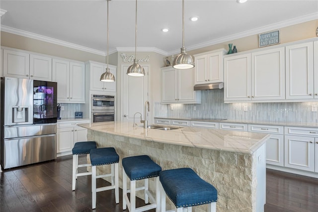 kitchen with stainless steel appliances, white cabinets, a sink, and under cabinet range hood