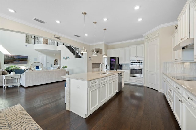 kitchen featuring visible vents, dark wood finished floors, stainless steel appliances, under cabinet range hood, and a sink