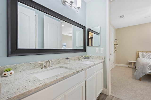 full bathroom with double vanity, baseboards, visible vents, and a sink