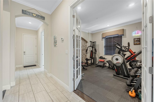 workout area featuring arched walkways, ornamental molding, recessed lighting, and baseboards