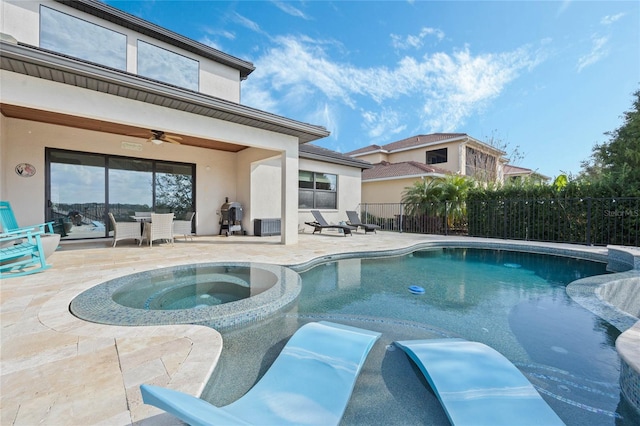 view of pool with ceiling fan, a patio, fence, and a pool with connected hot tub