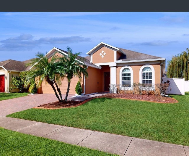 ranch-style home featuring a garage and a front lawn