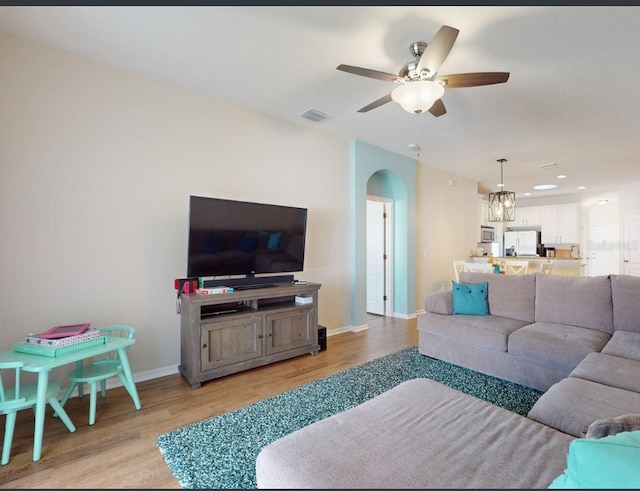 living room featuring light hardwood / wood-style flooring and ceiling fan