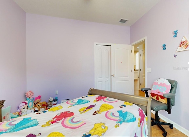 bedroom with light hardwood / wood-style floors and a closet