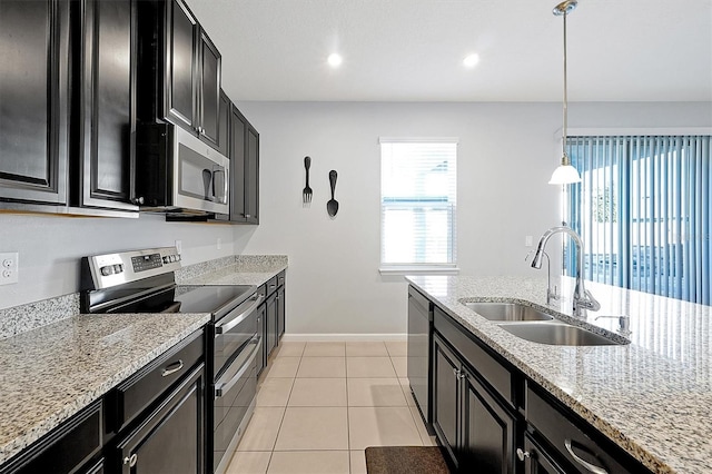 kitchen featuring sink, light stone counters, hanging light fixtures, light tile patterned floors, and stainless steel appliances