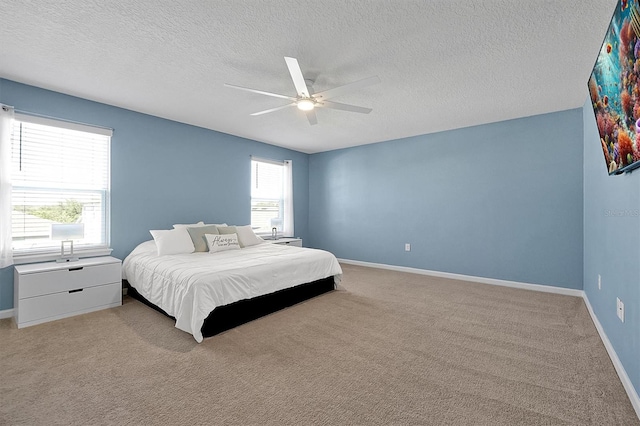 carpeted bedroom with multiple windows, a textured ceiling, and ceiling fan