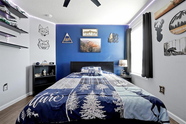 bedroom featuring ceiling fan, hardwood / wood-style floors, and a textured ceiling