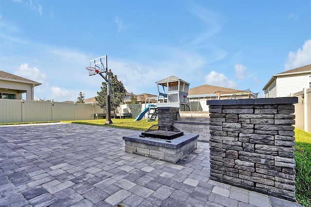 view of patio featuring a playground and a fire pit