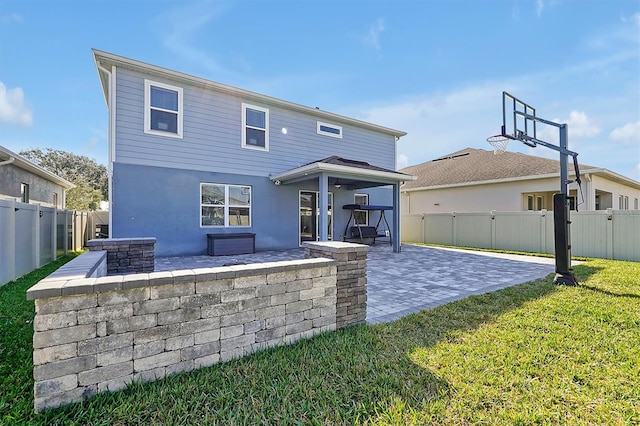 back of property with a lawn and a patio area